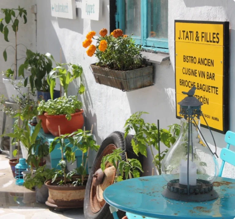 Charmig gård med blommor och skyltar vid Restaurang Gotland.